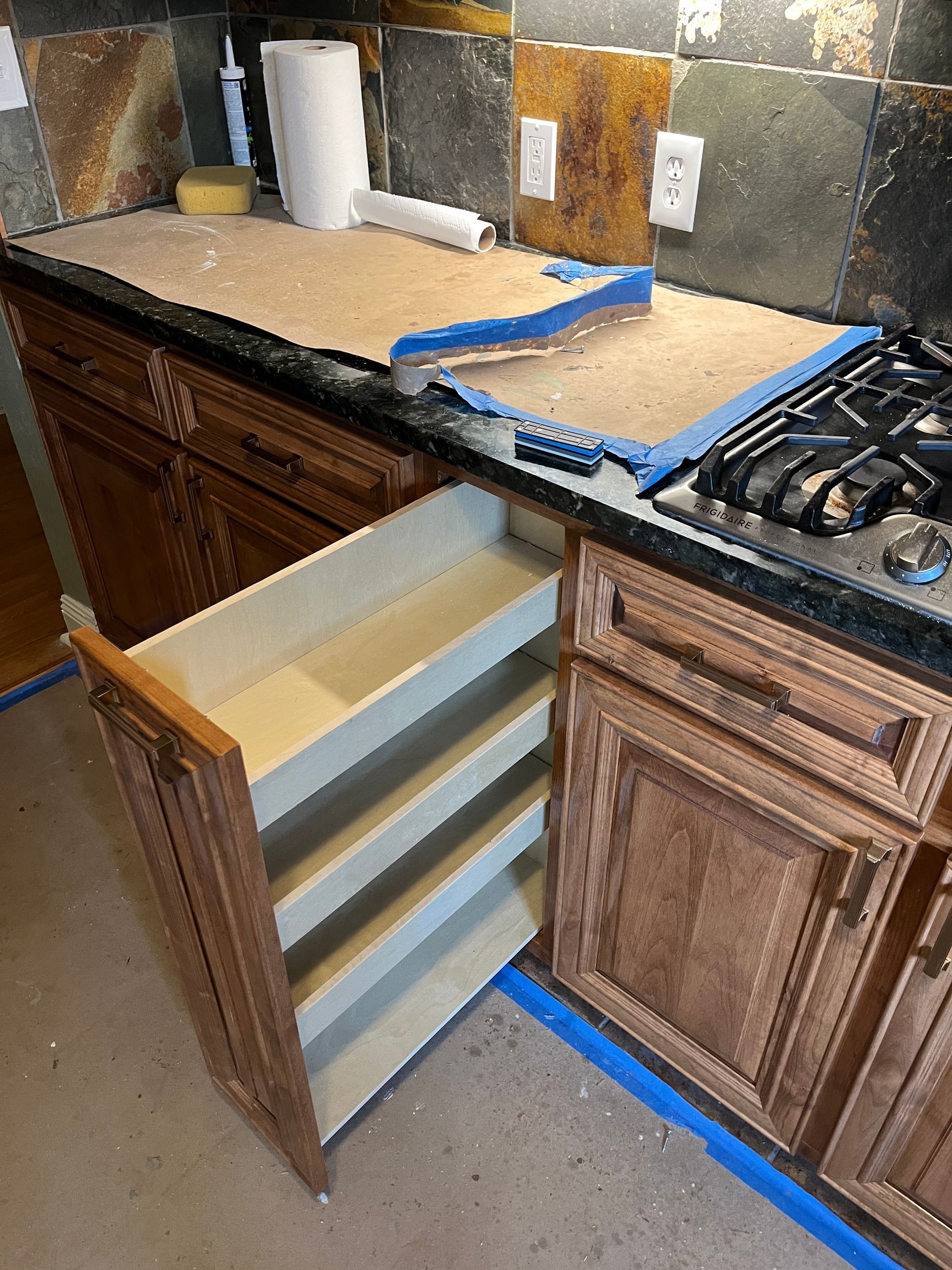 A kitchen with wooden cabinets and a stove top oven.