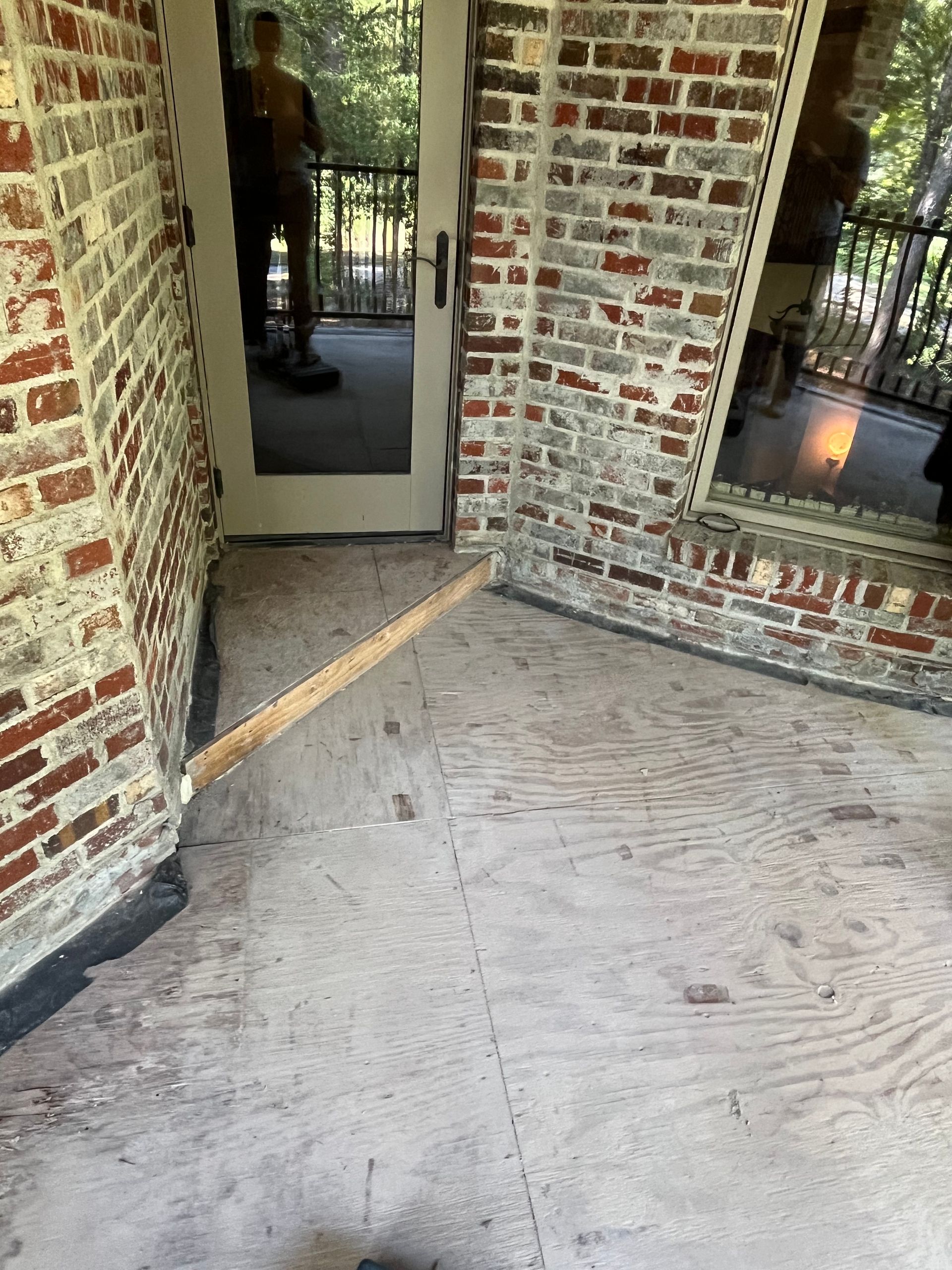 A room with a brick wall and a mirror on the wall.