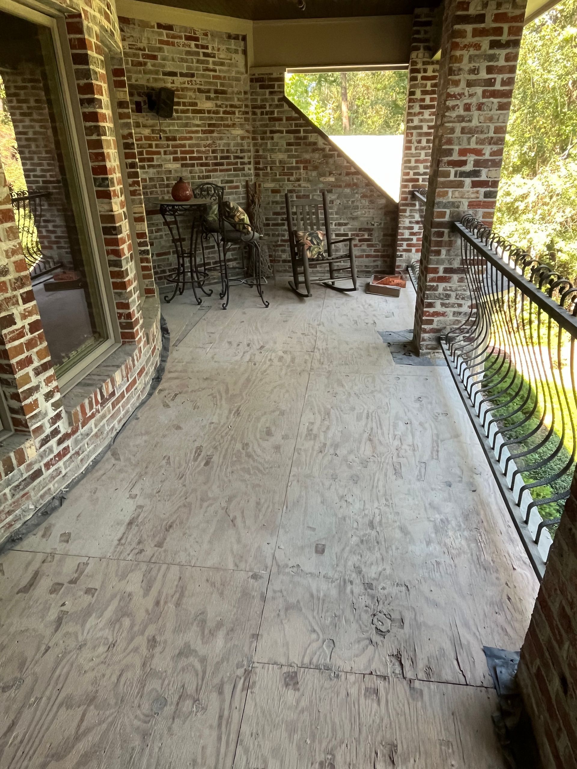 A brick porch with a table and chairs on it