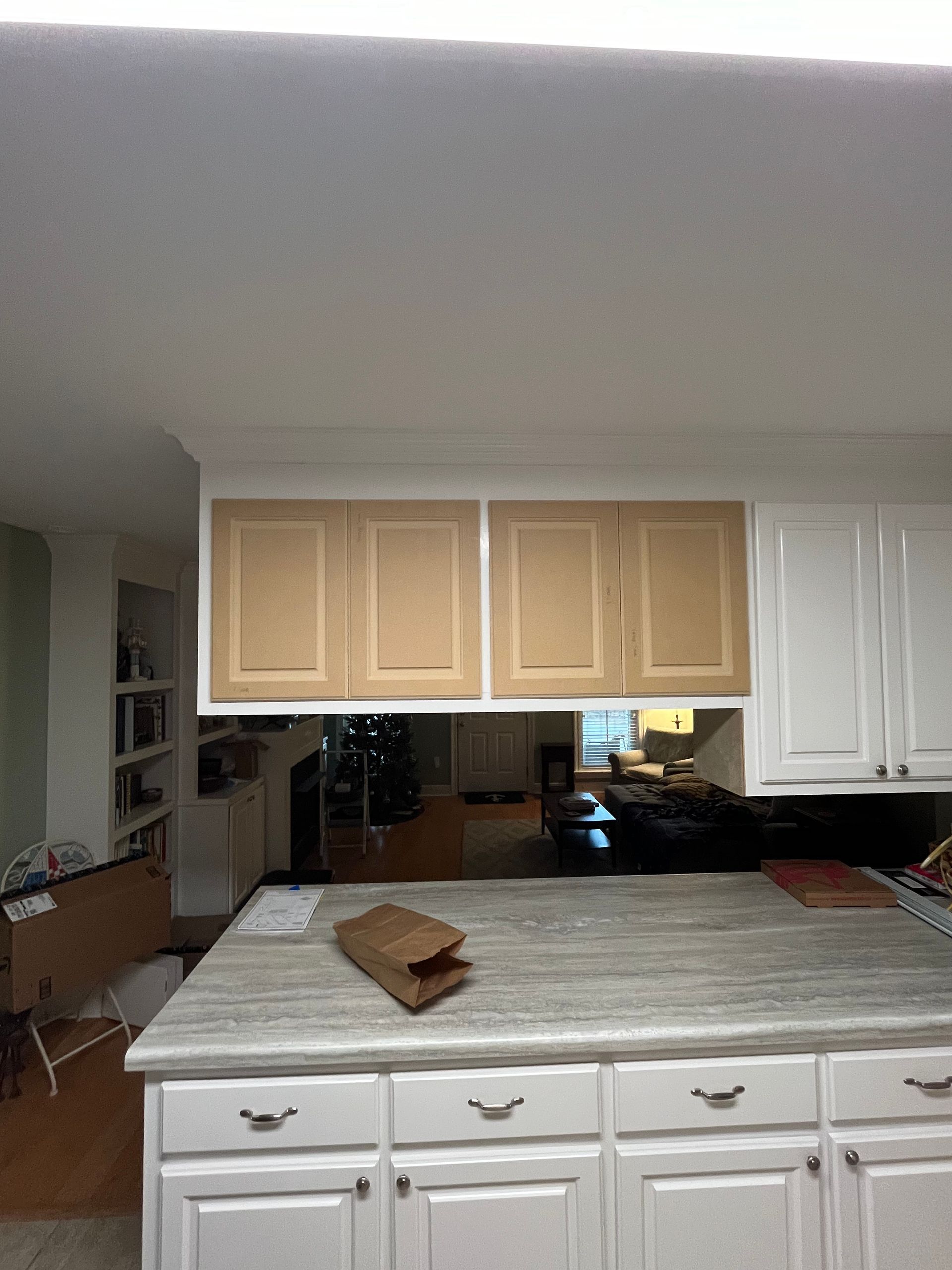 A kitchen with white cabinets and marble counter tops