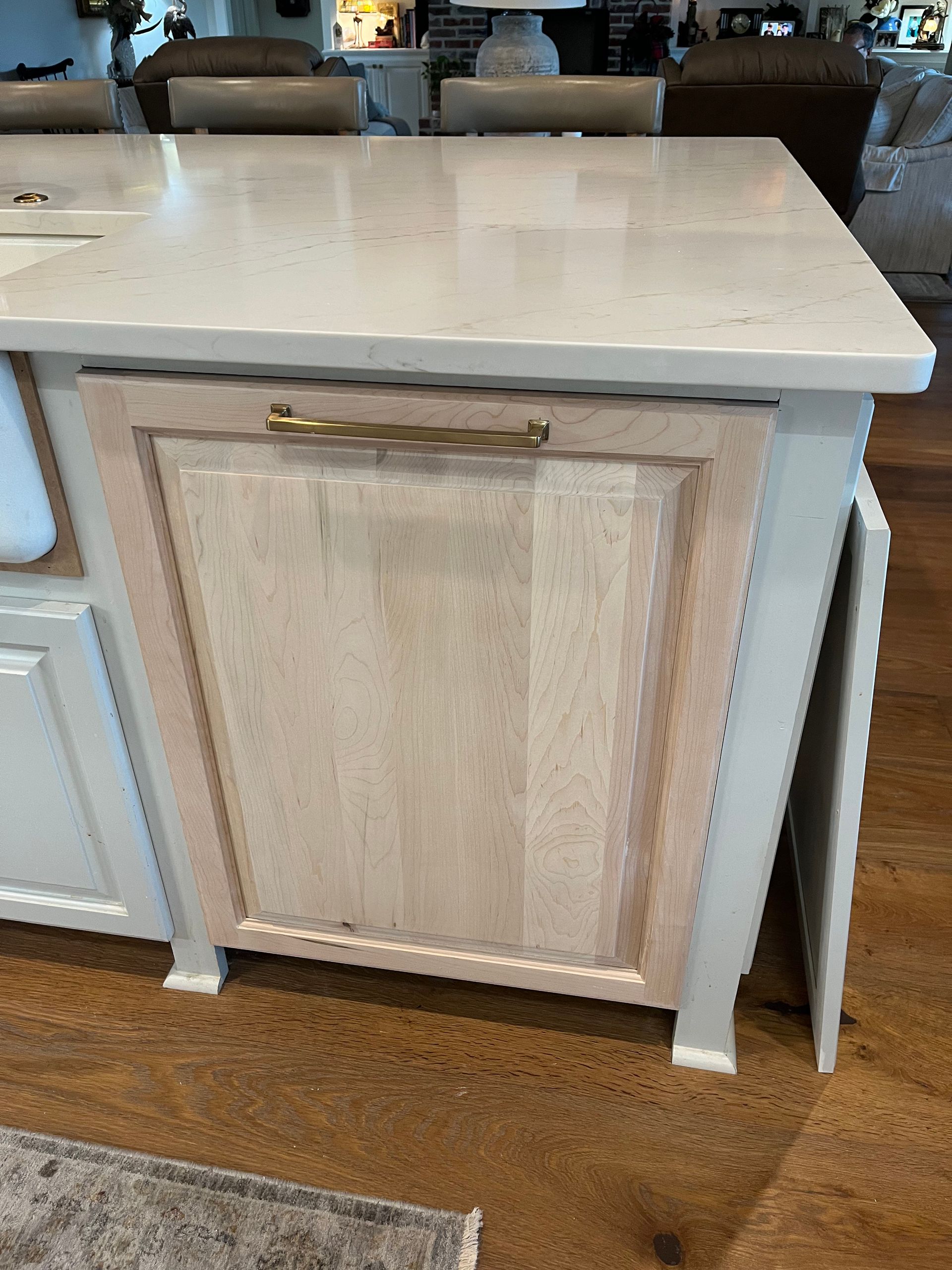 A kitchen island with a wooden door and a white counter top.