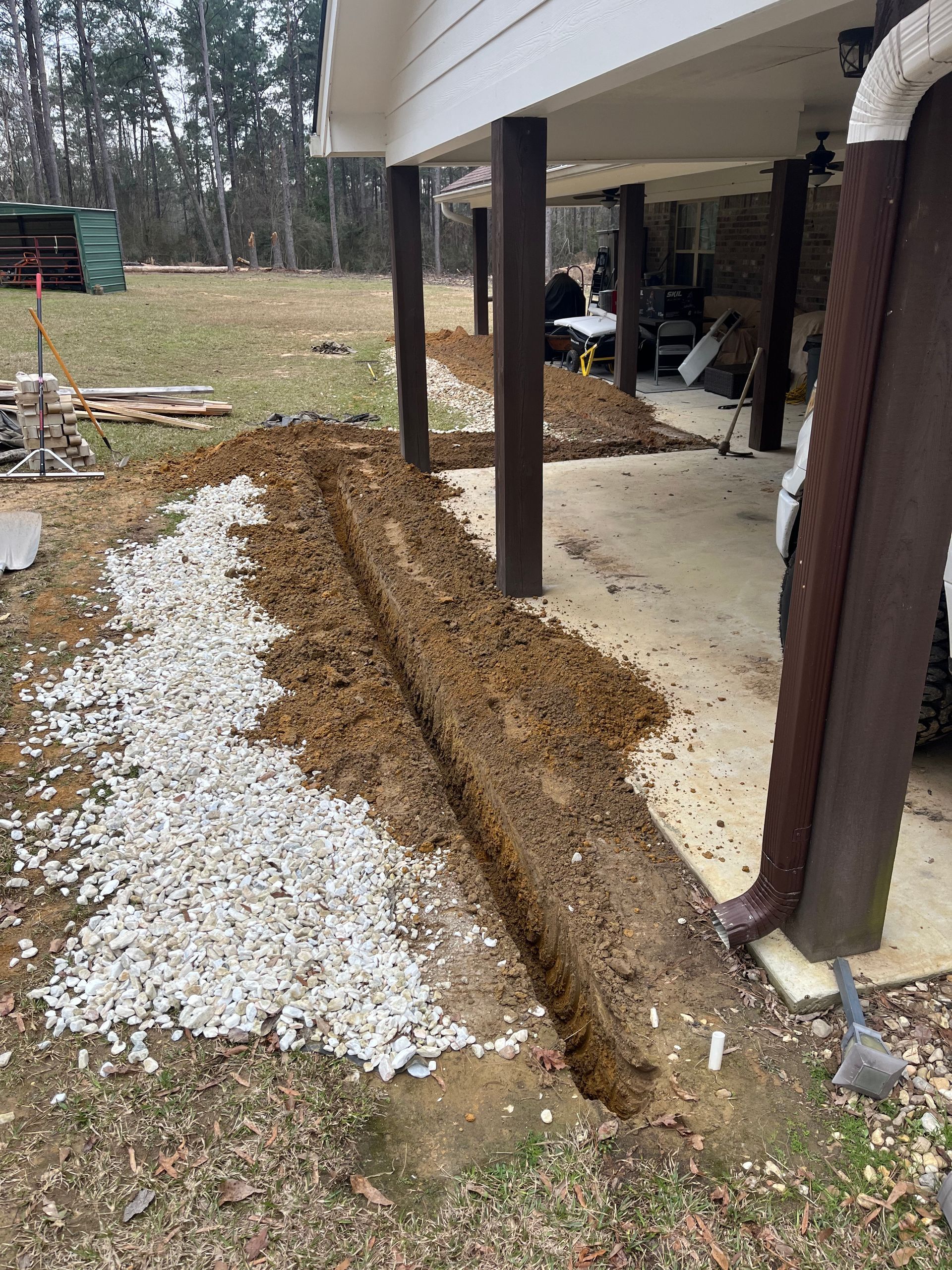 A drainage system is being installed under a house.