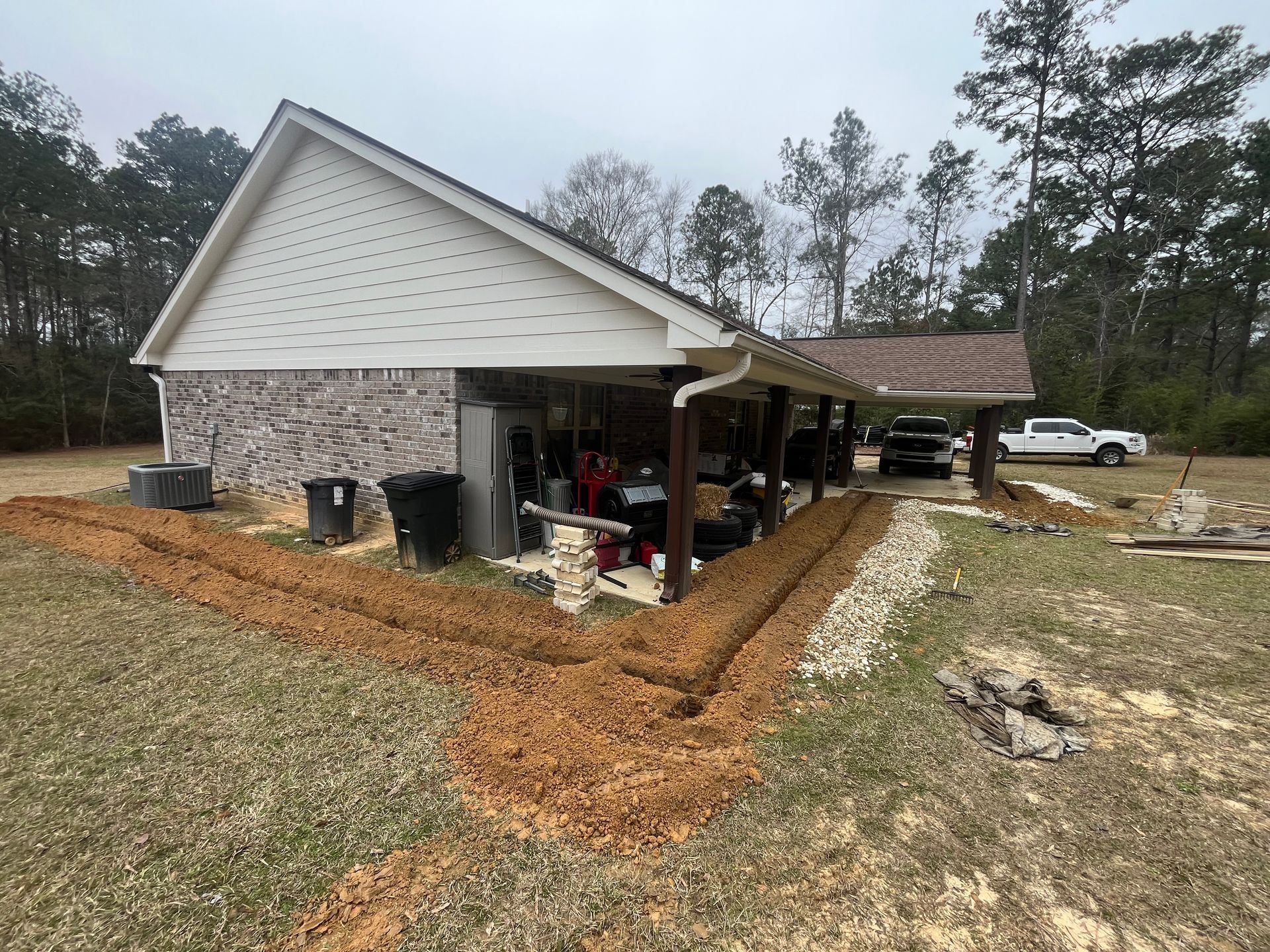 A house with a covered porch and a lot of dirt in front of it.