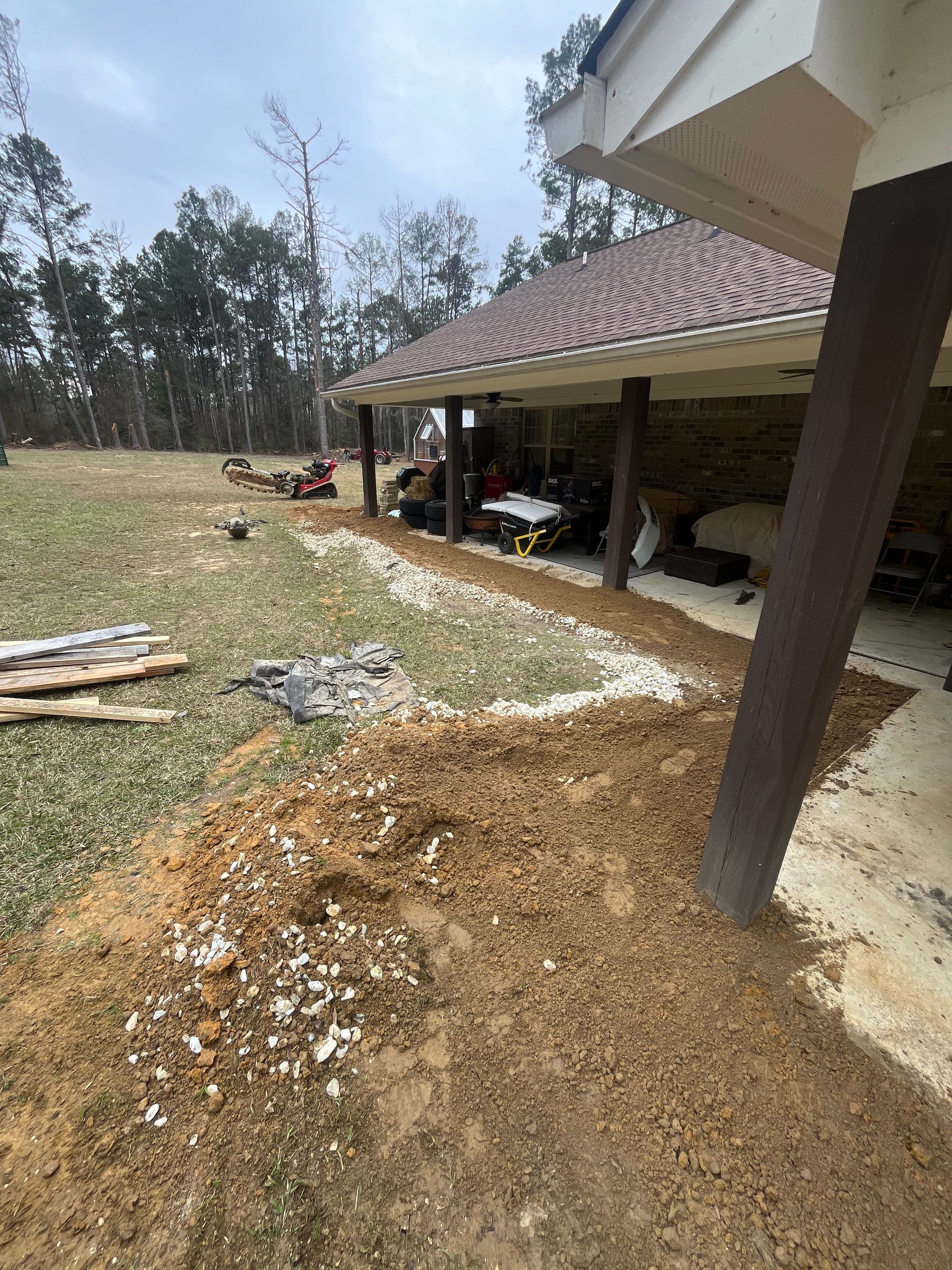 A house with a covered porch and a lot of dirt in front of it.