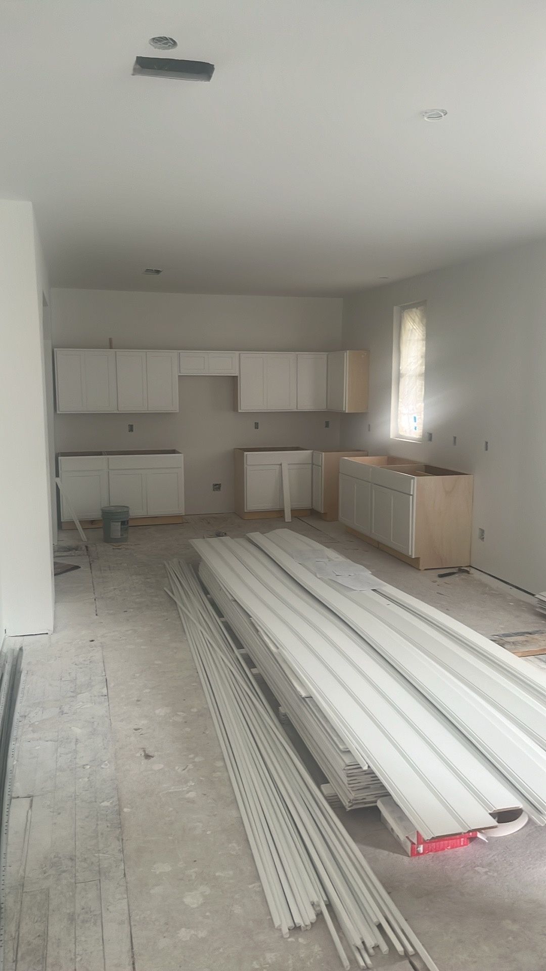 A kitchen under construction with a lot of pieces of drywall on the floor.