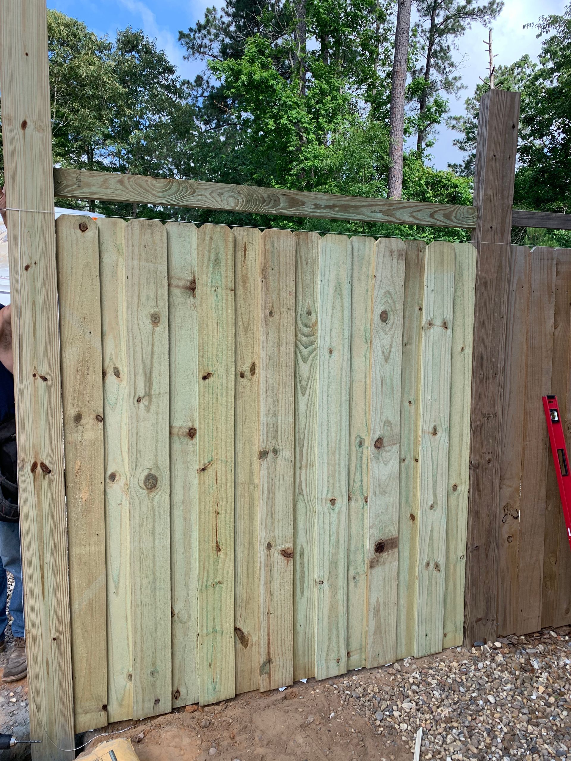 A wooden fence is being built next to a red level.