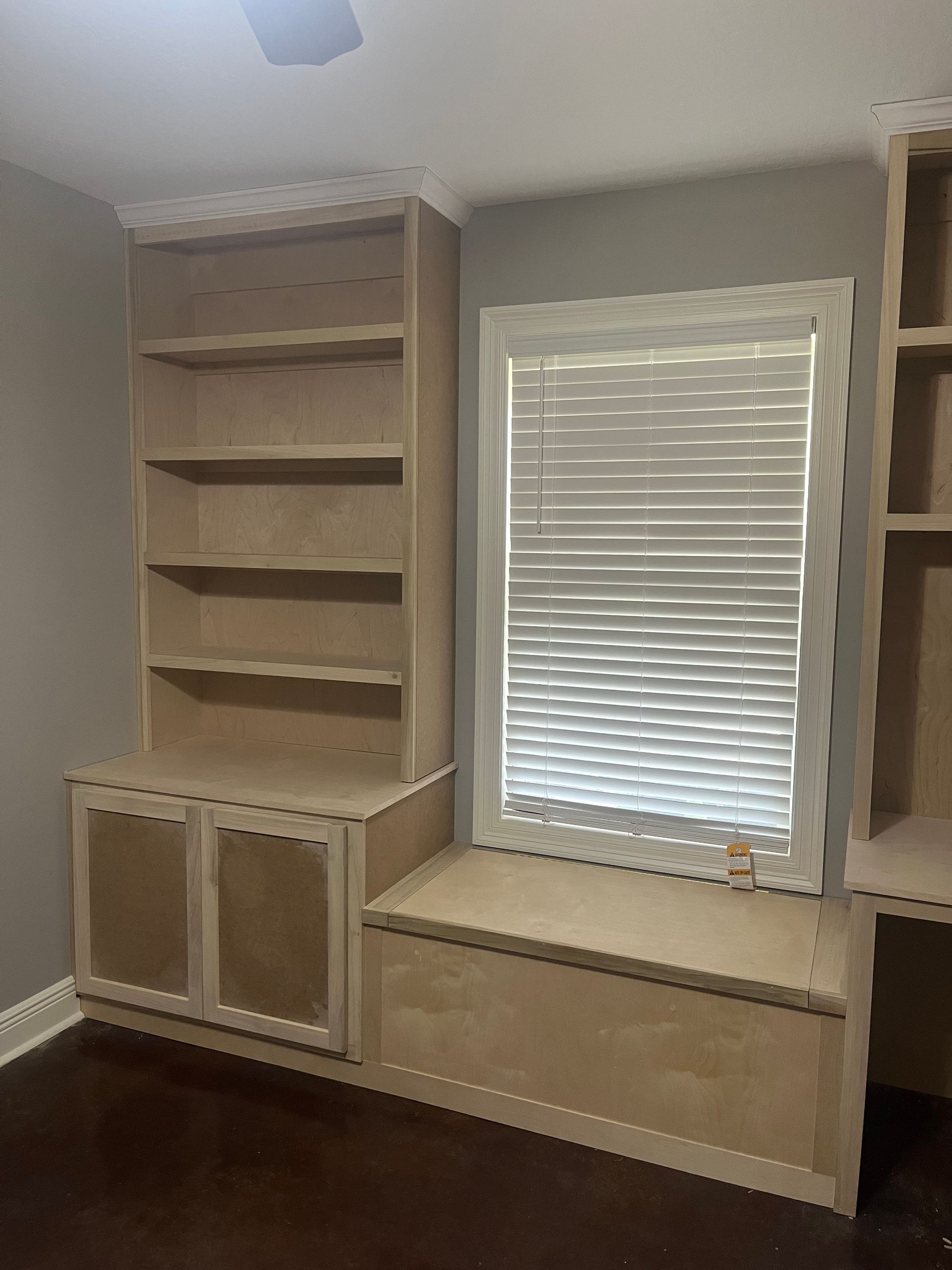 A room with a window , shelves , and a bench.