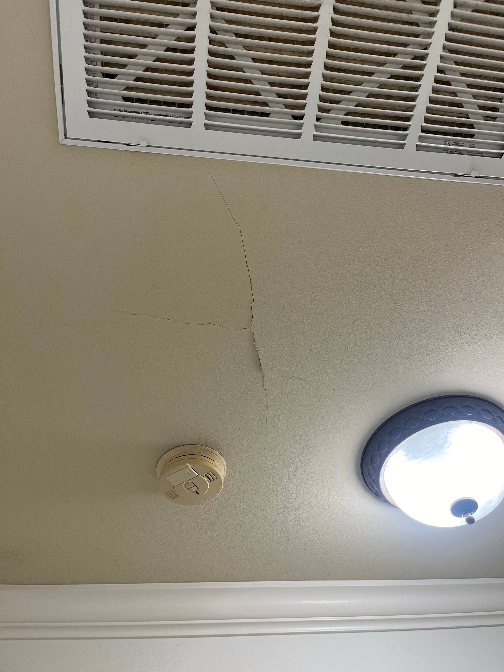 A ceiling with a fan and a smoke detector on it.