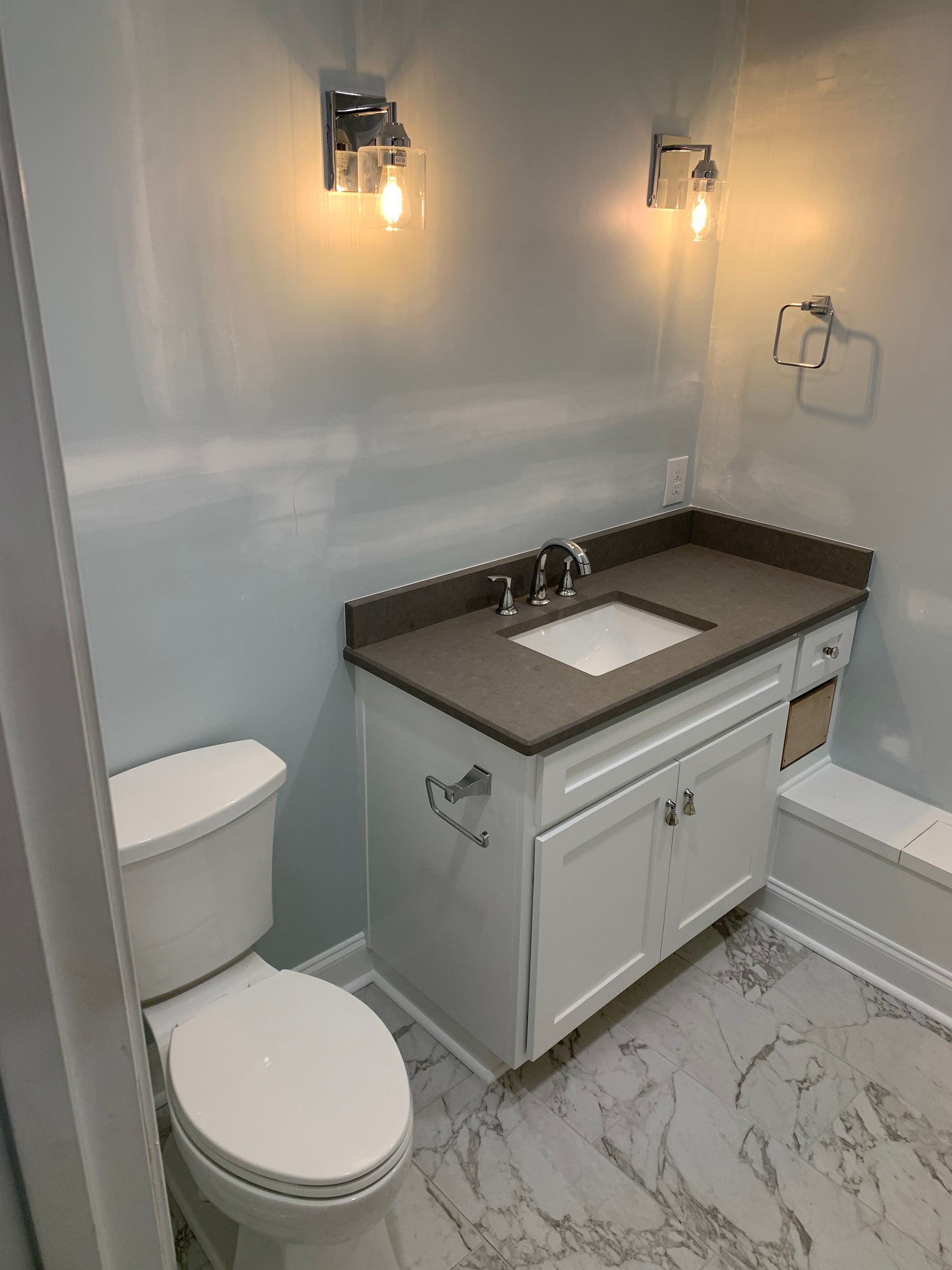 A bathroom with a toilet , sink , and bathtub.