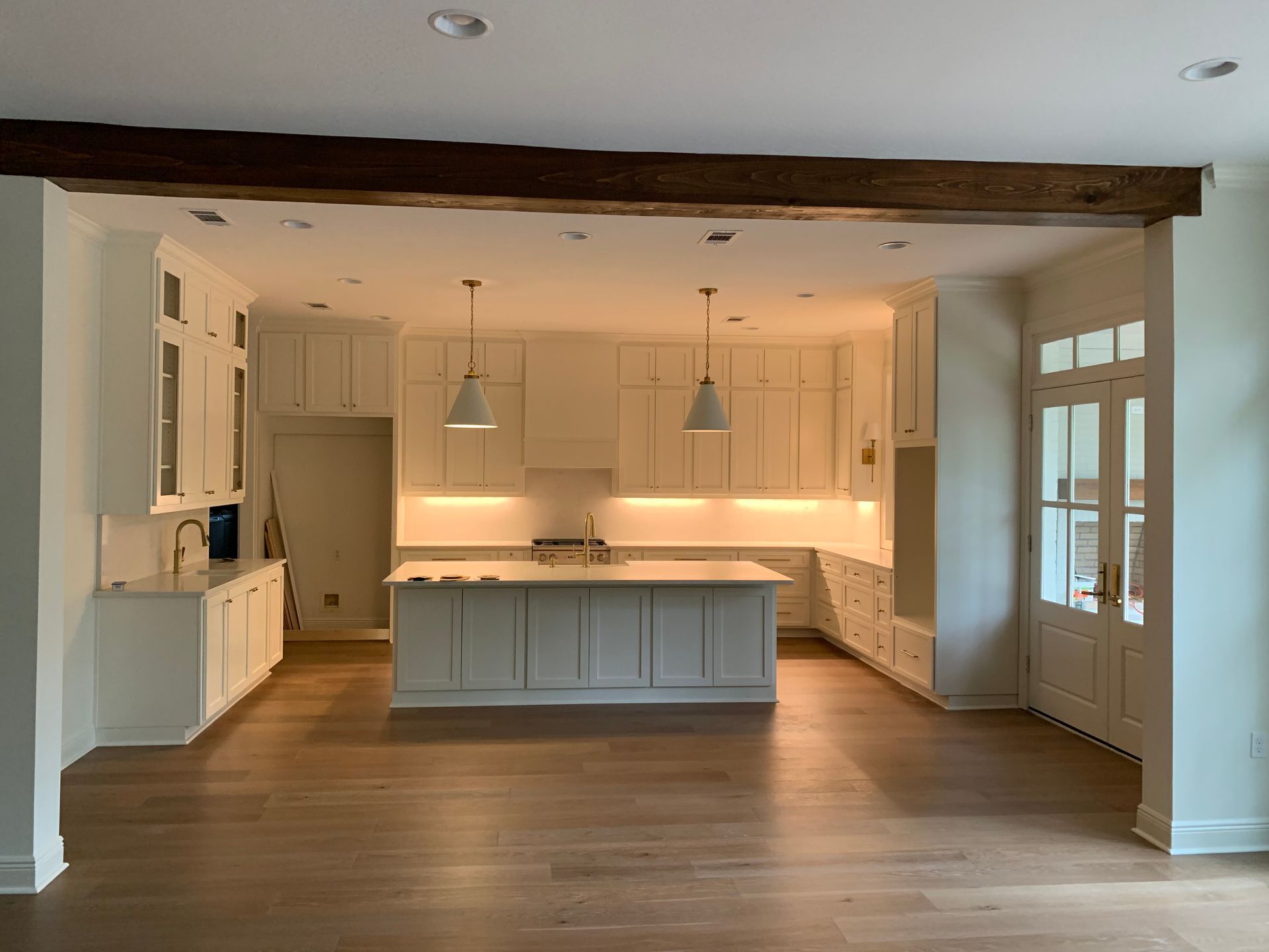 A kitchen with white cabinets and a large island in the middle of the room.