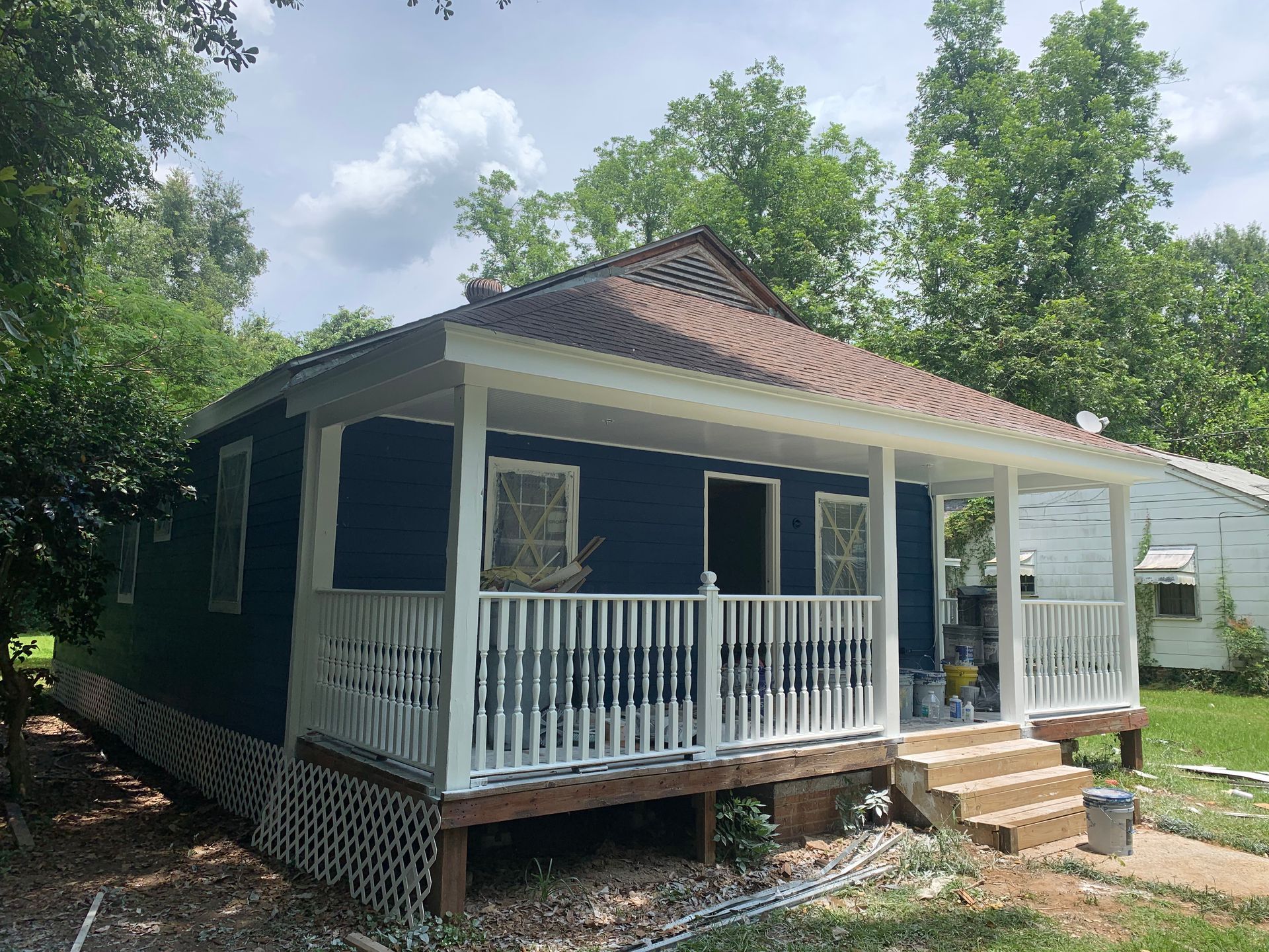 A blue house with a white porch and stairs
