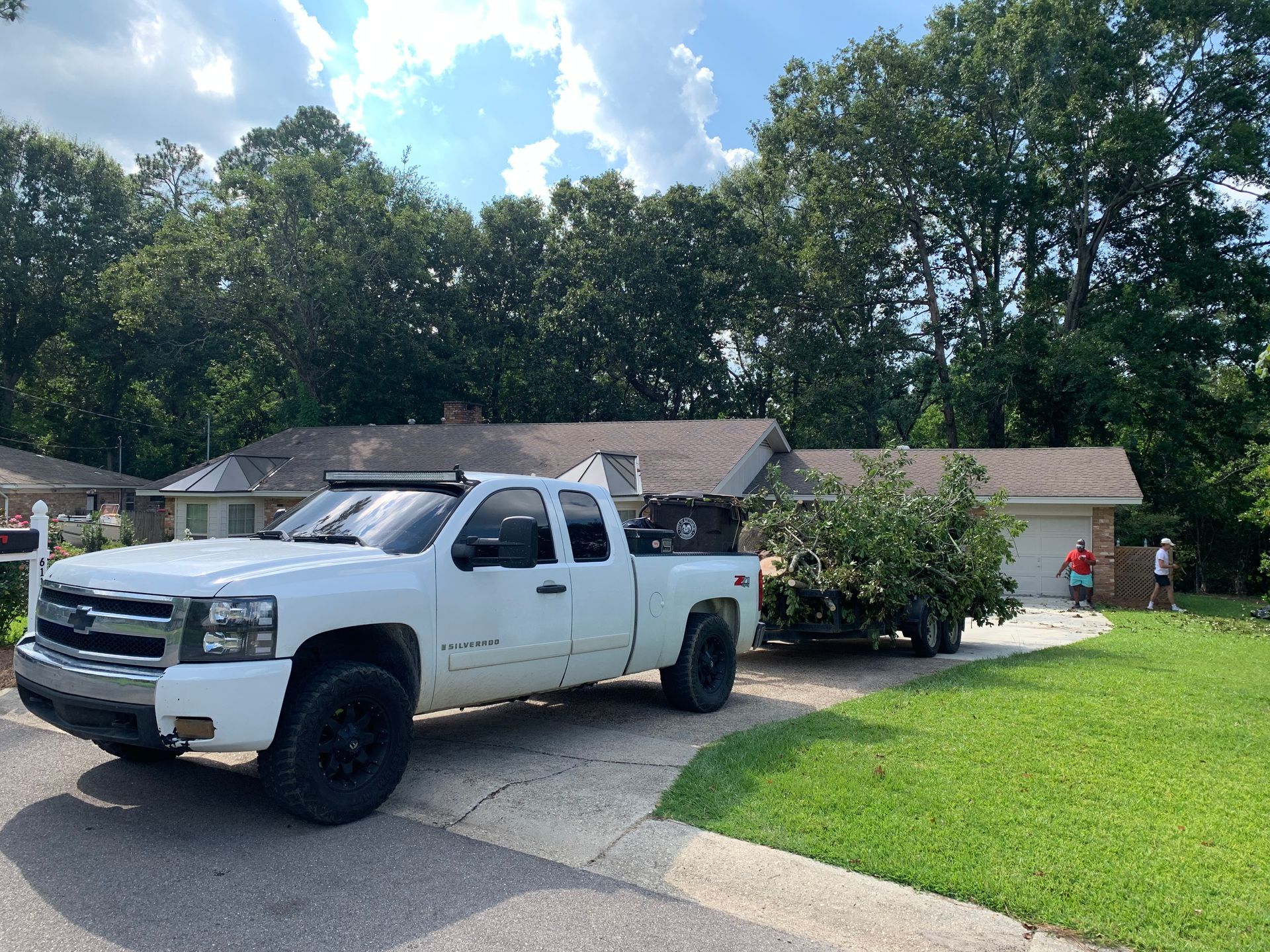 A white truck is parked in front of a house.