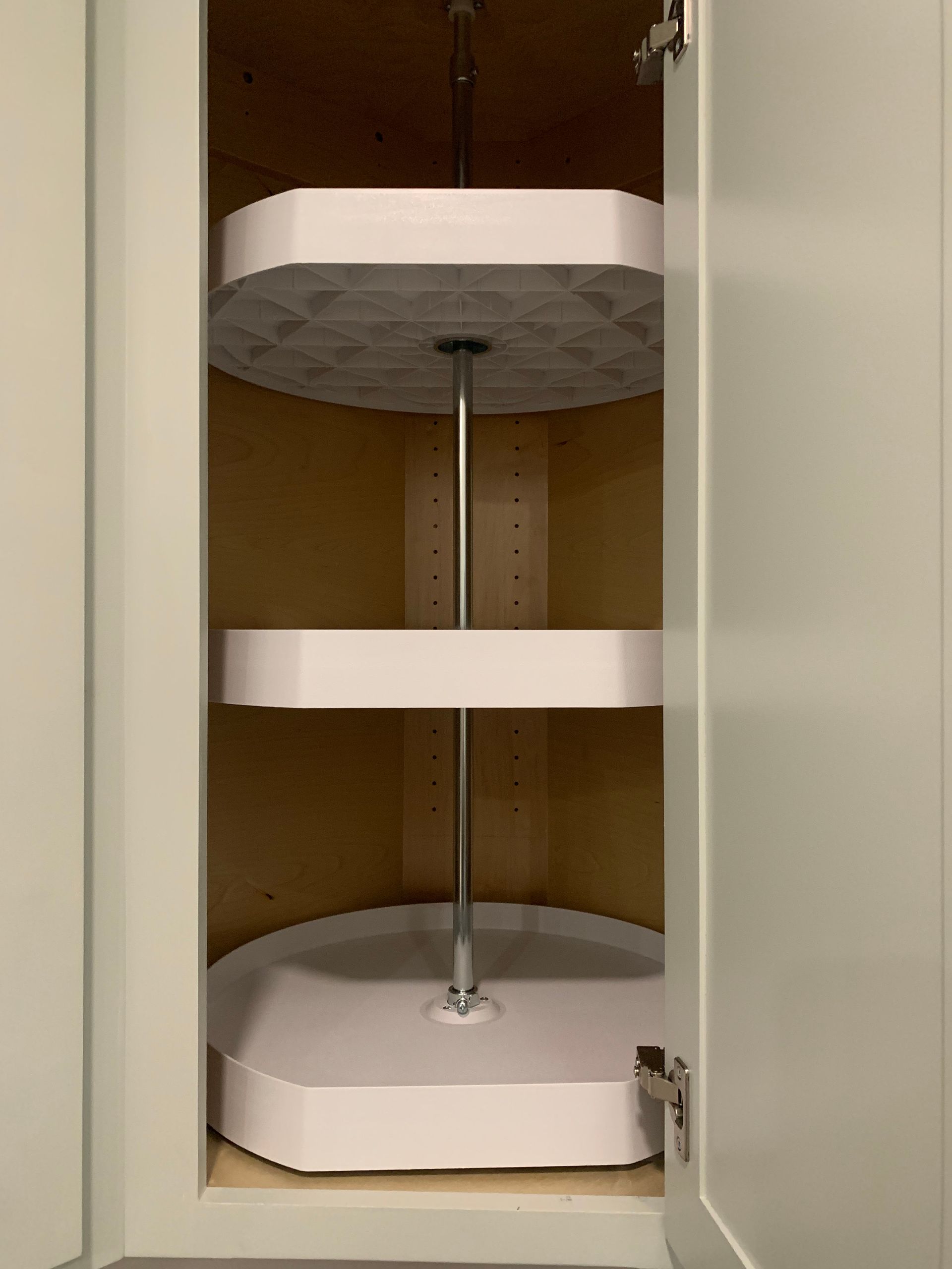 A kitchen cabinet with a rotating shelf inside of it.