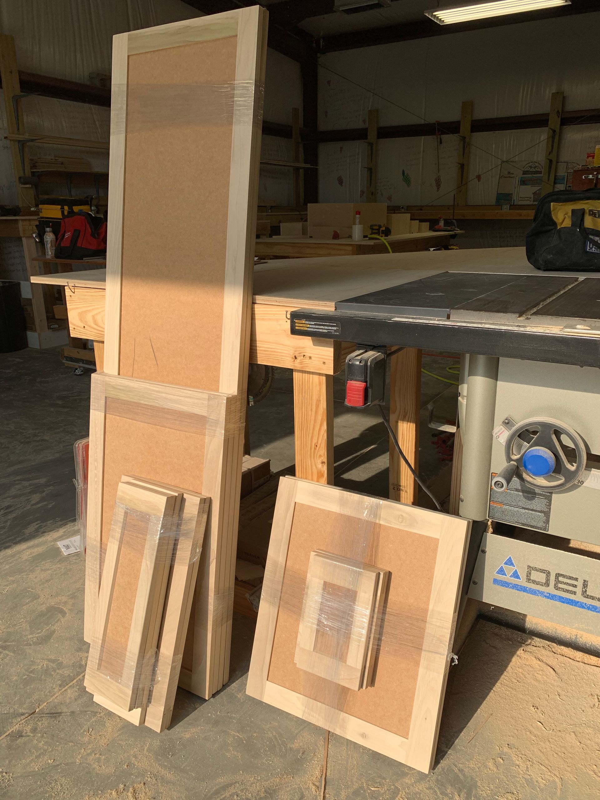 A bunch of wood sitting on top of a table next to a table saw.