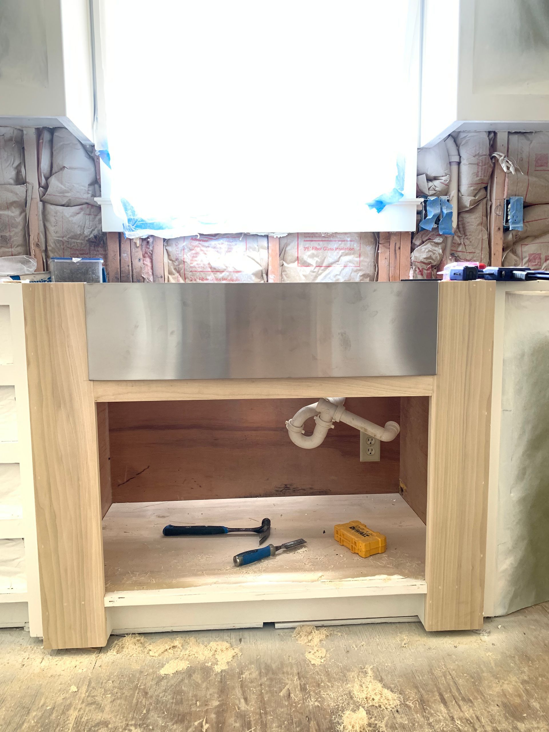 A stainless steel sink is being built in a kitchen.