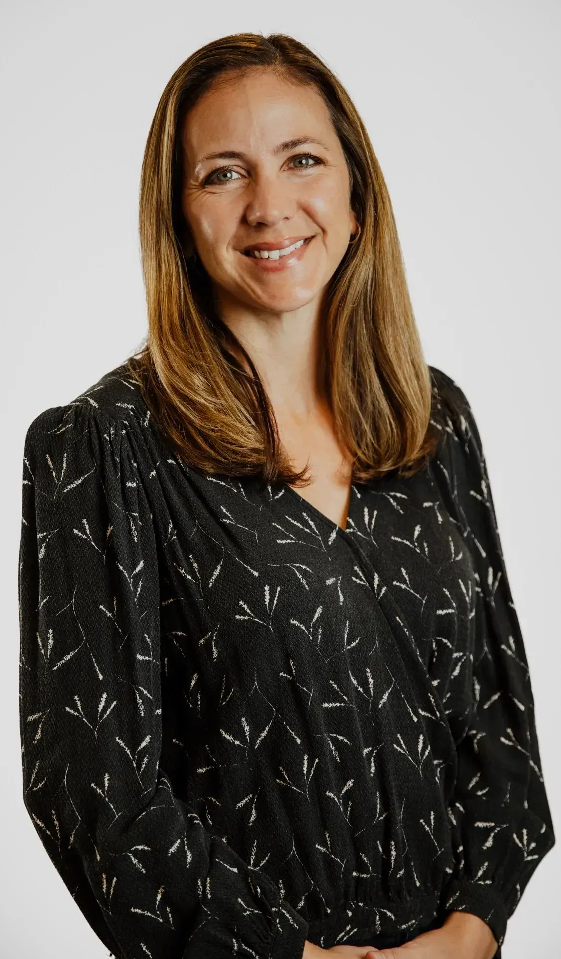 A woman in a black shirt is smiling for the camera.