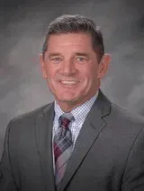 A man in a suit and tie is smiling for the camera.