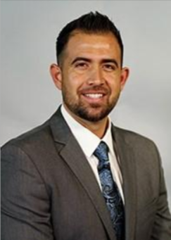 A man in a suit and tie is smiling for the camera.