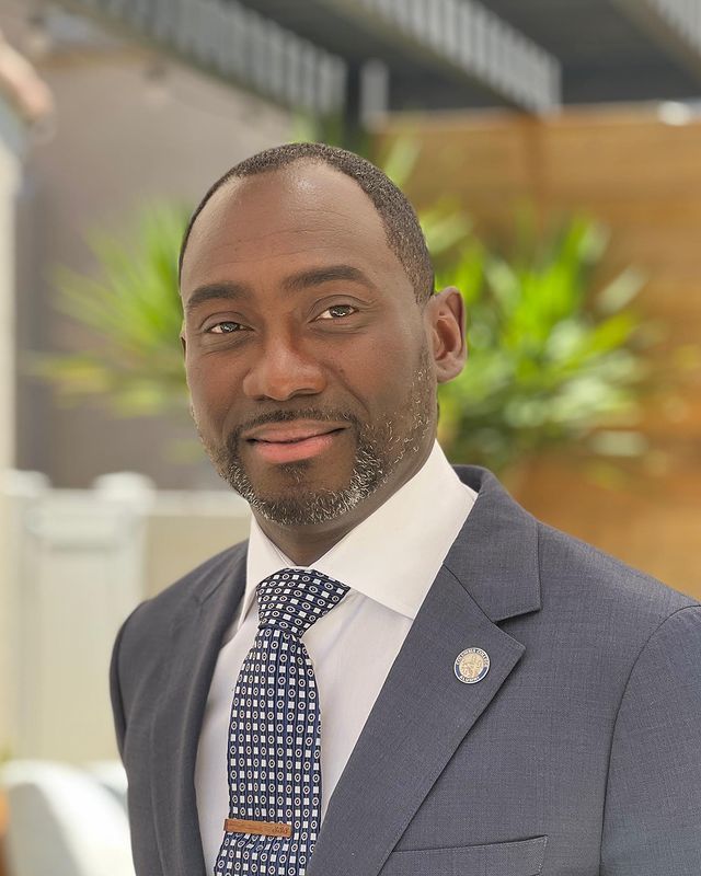 A man in a suit and tie is smiling for the camera.