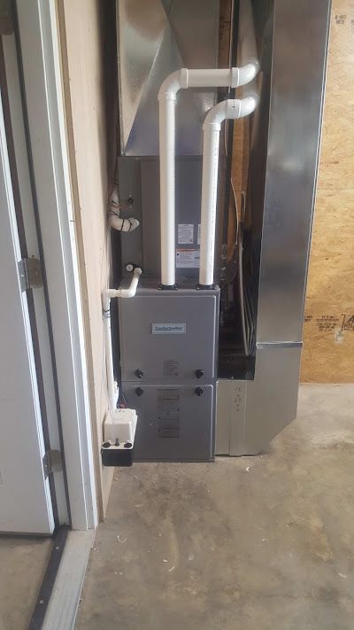 A furnace is installed in a room next to a door.