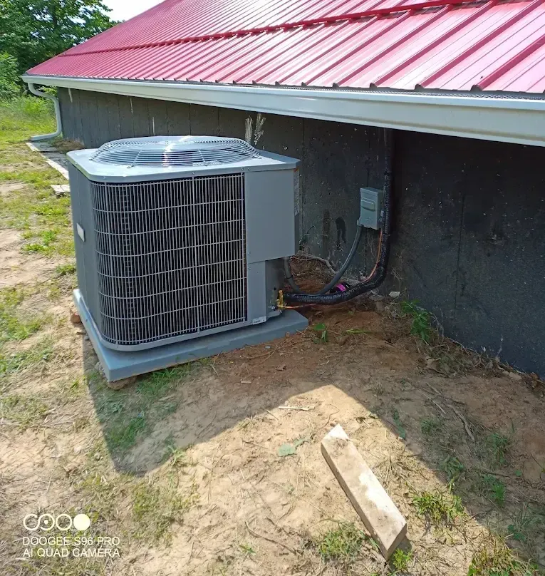 A room with a window and a air conditioner hanging from the ceiling.