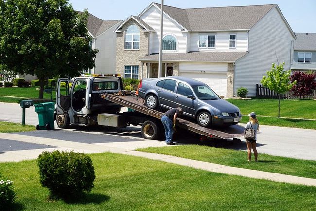 A tow truck with a car on the back of it