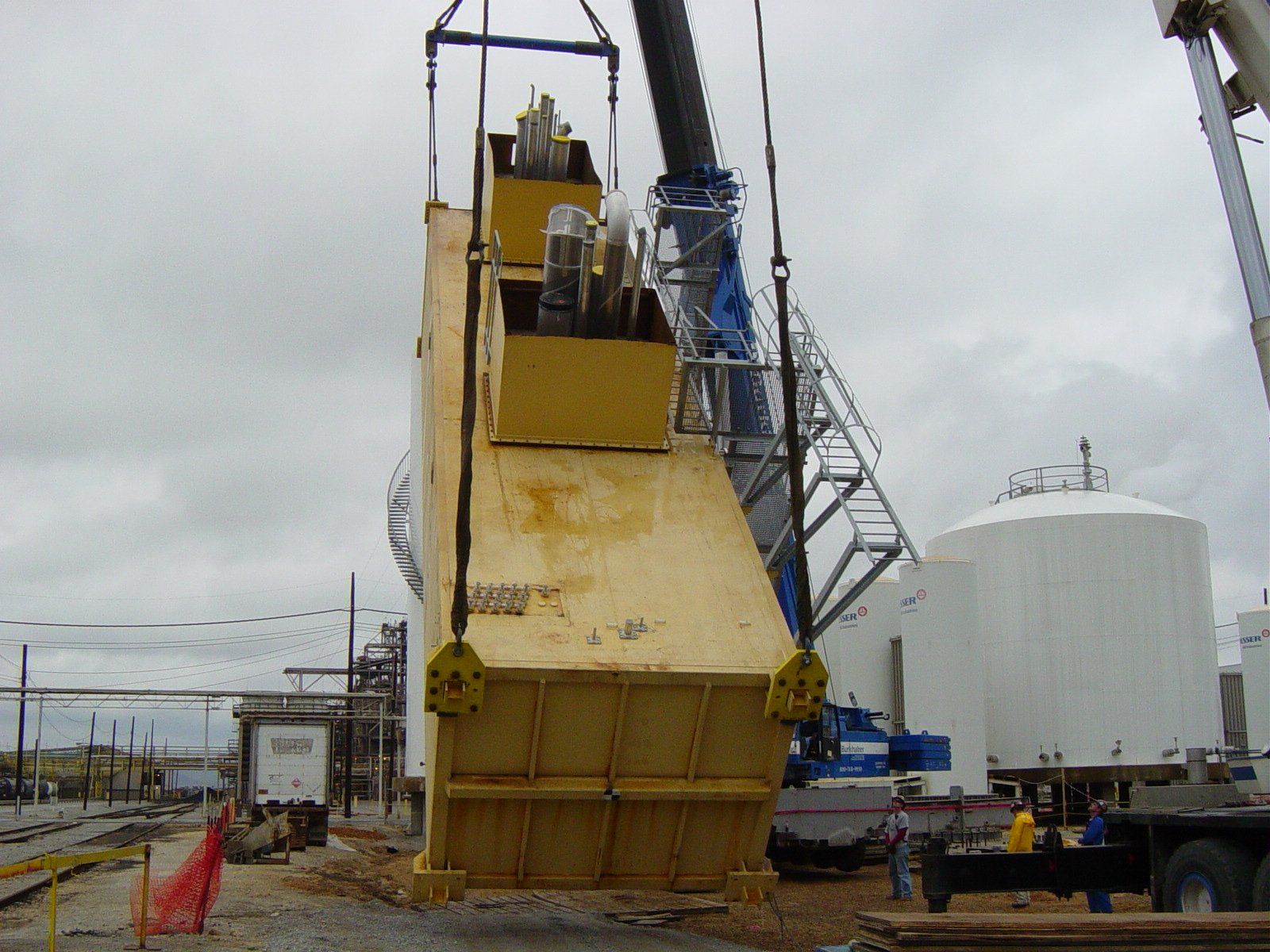 A large machine is being lifted by a large crane