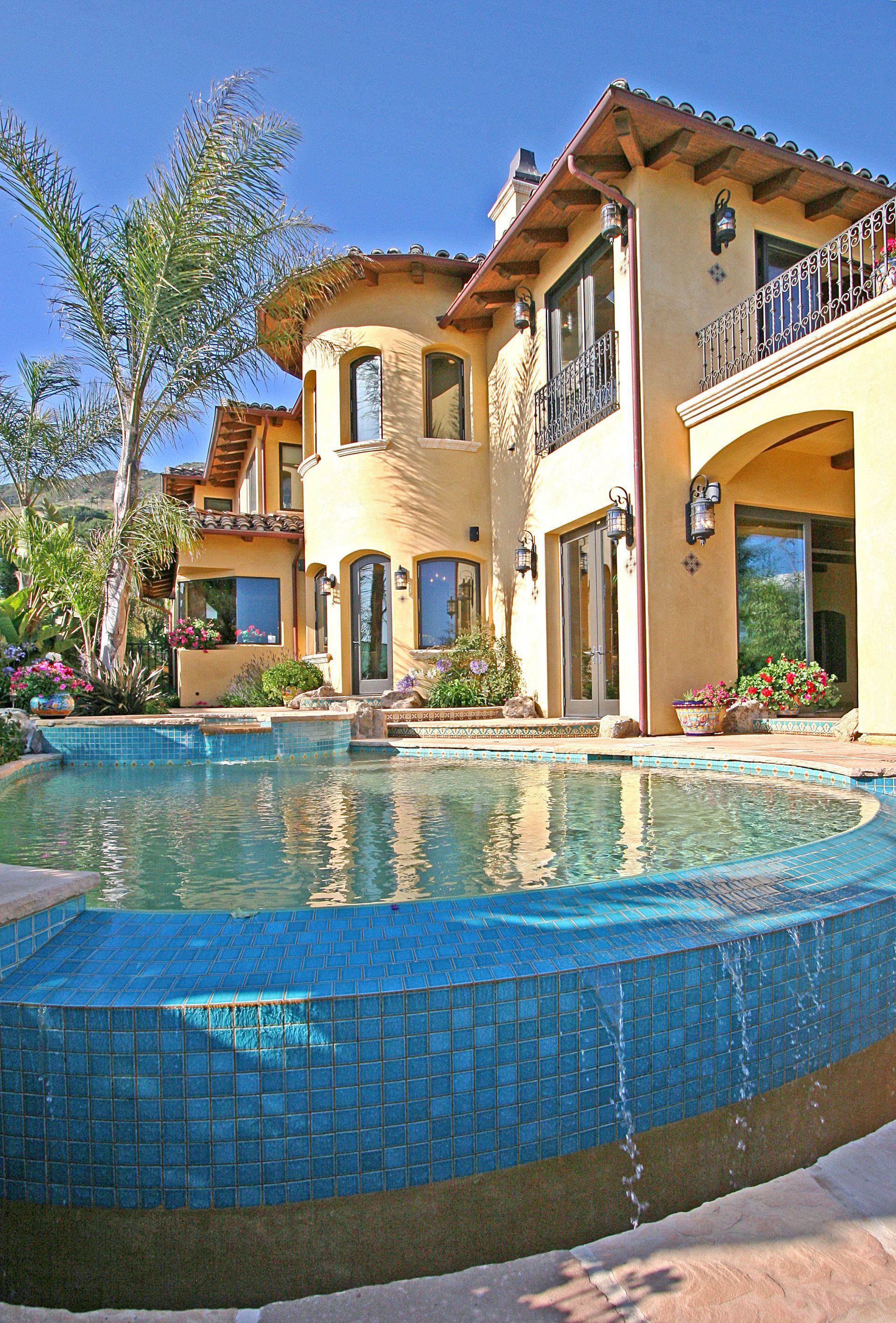 A kitchen with a large island and stools in it.