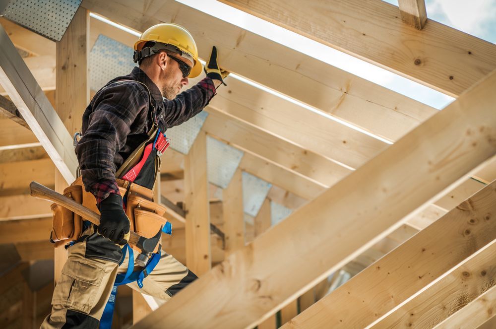 A construction worker is working on a wooden structure.