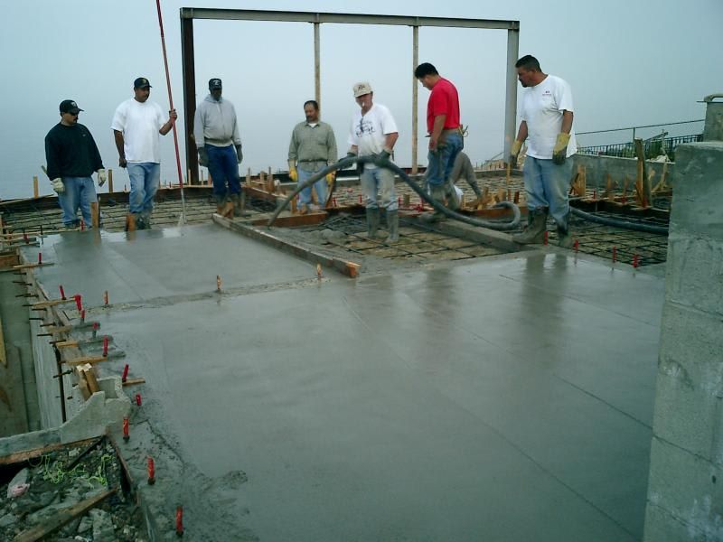 A group of men are working on a concrete floor.