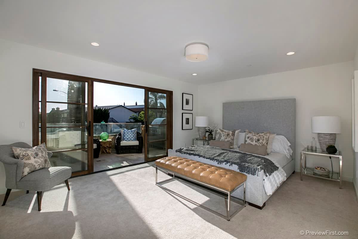 A bedroom with a large bed and sliding glass doors.