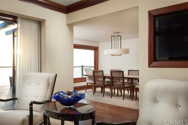A living room with chairs, a table and a television.