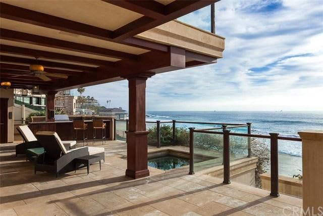 A patio with a view of the ocean and a pool.