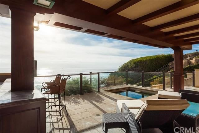 A patio with a view of the ocean and a swimming pool.