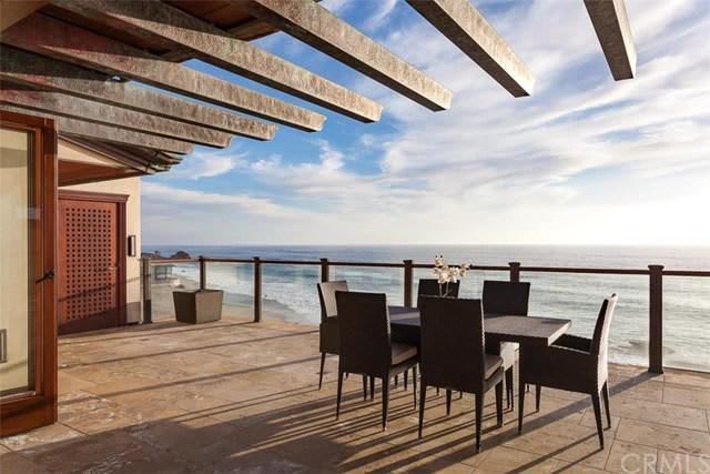 A patio with a table and chairs overlooking the ocean.