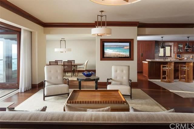 A living room with a couch and chairs and a tv on the wall.