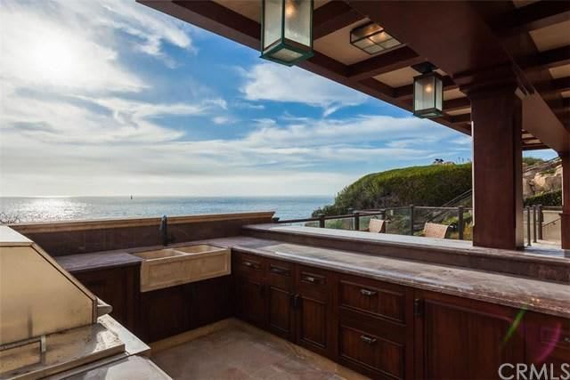 A kitchen with a view of the ocean and a grill.