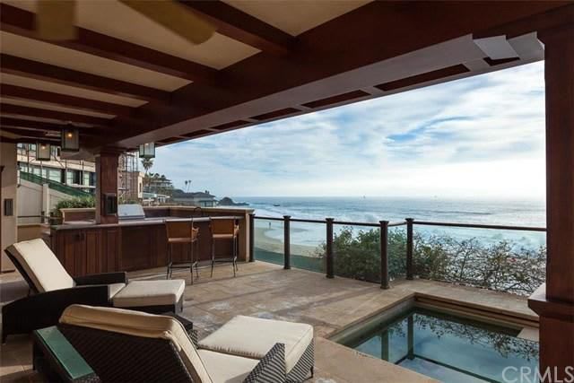 A patio with a view of the ocean and a pool.
