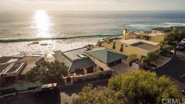 An aerial view of a house on a cliff overlooking the ocean.