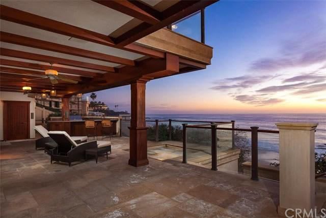 A large patio with a view of the ocean at sunset.