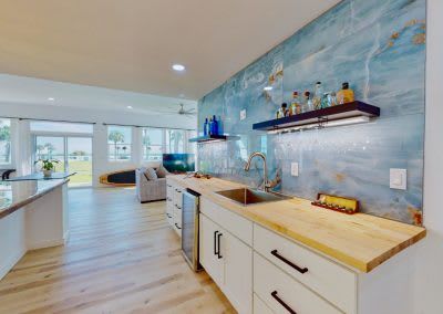 A kitchen with a sink, cabinets, and a bar.