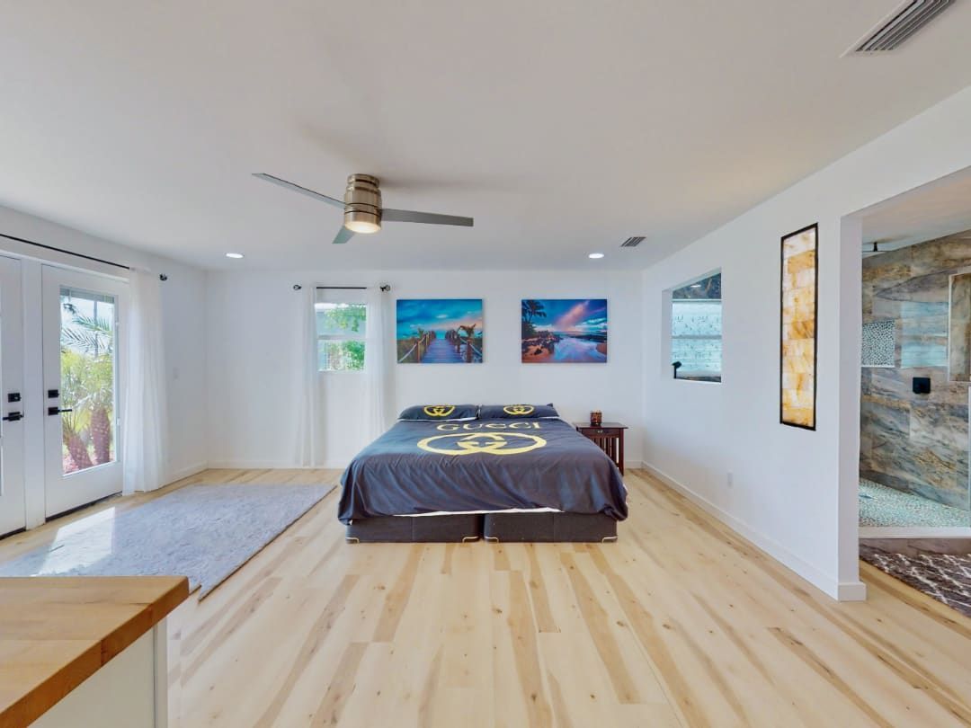 A bedroom with a bed and a ceiling fan.