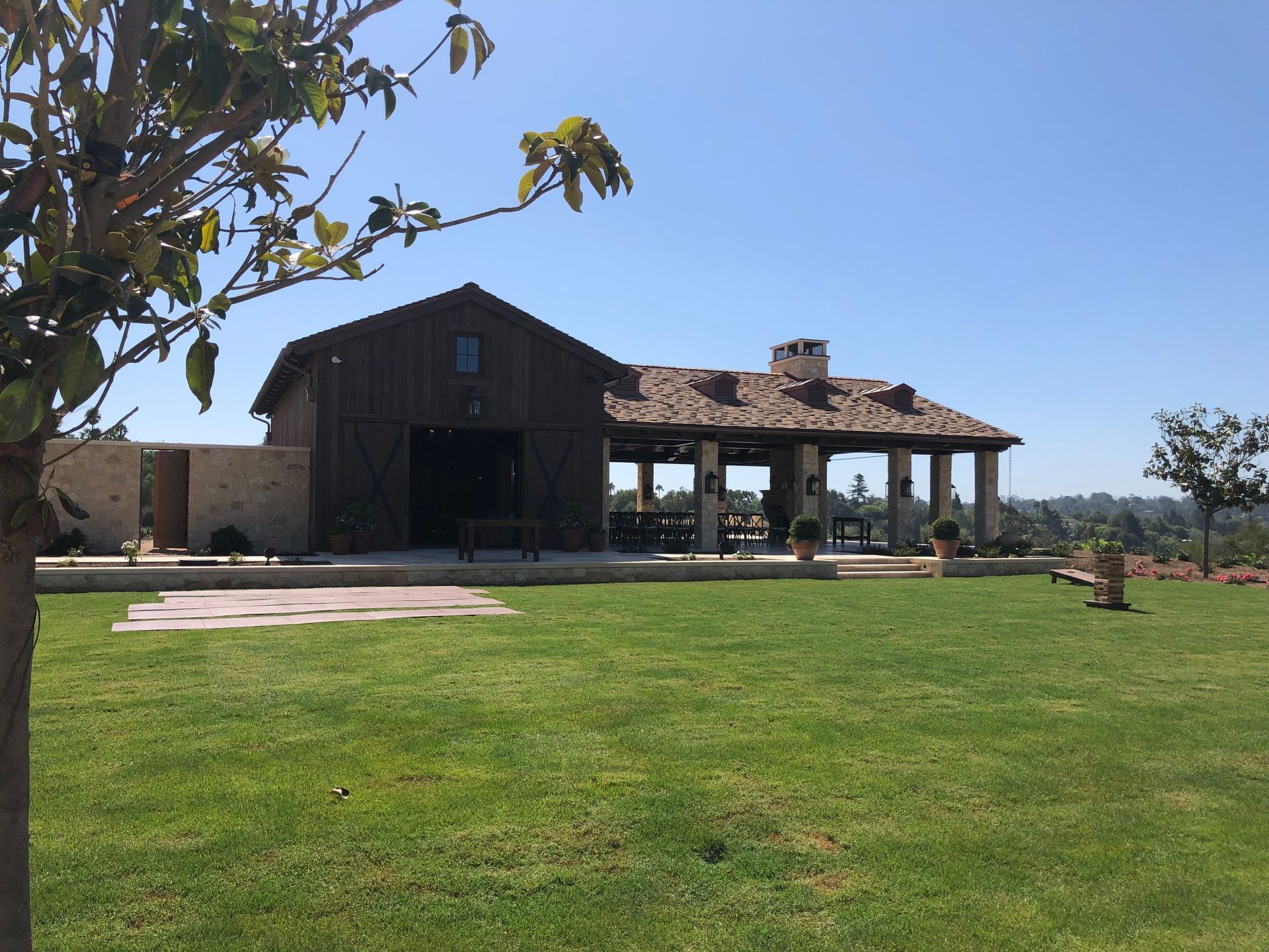A large house sits in the middle of a lush green field.