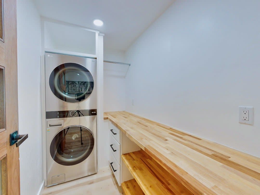 A laundry room with a washer and dryer stacked on top of each other.