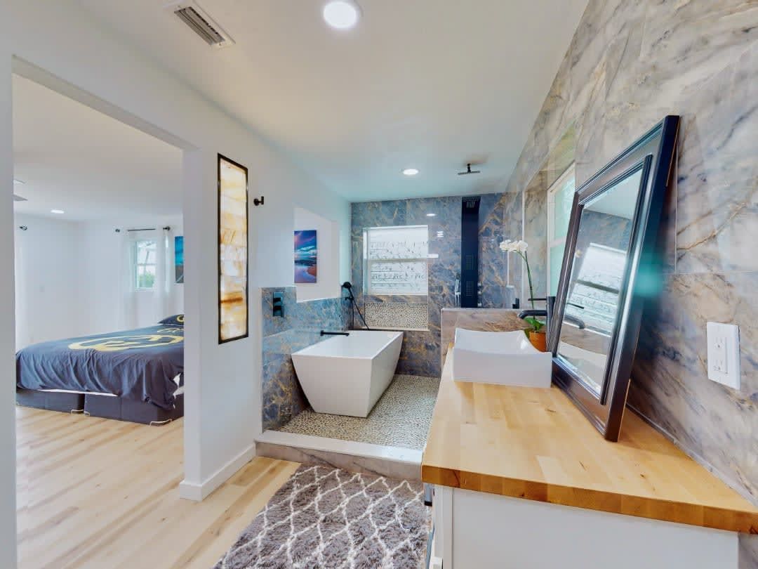 A bathroom with a tub, sink and mirror