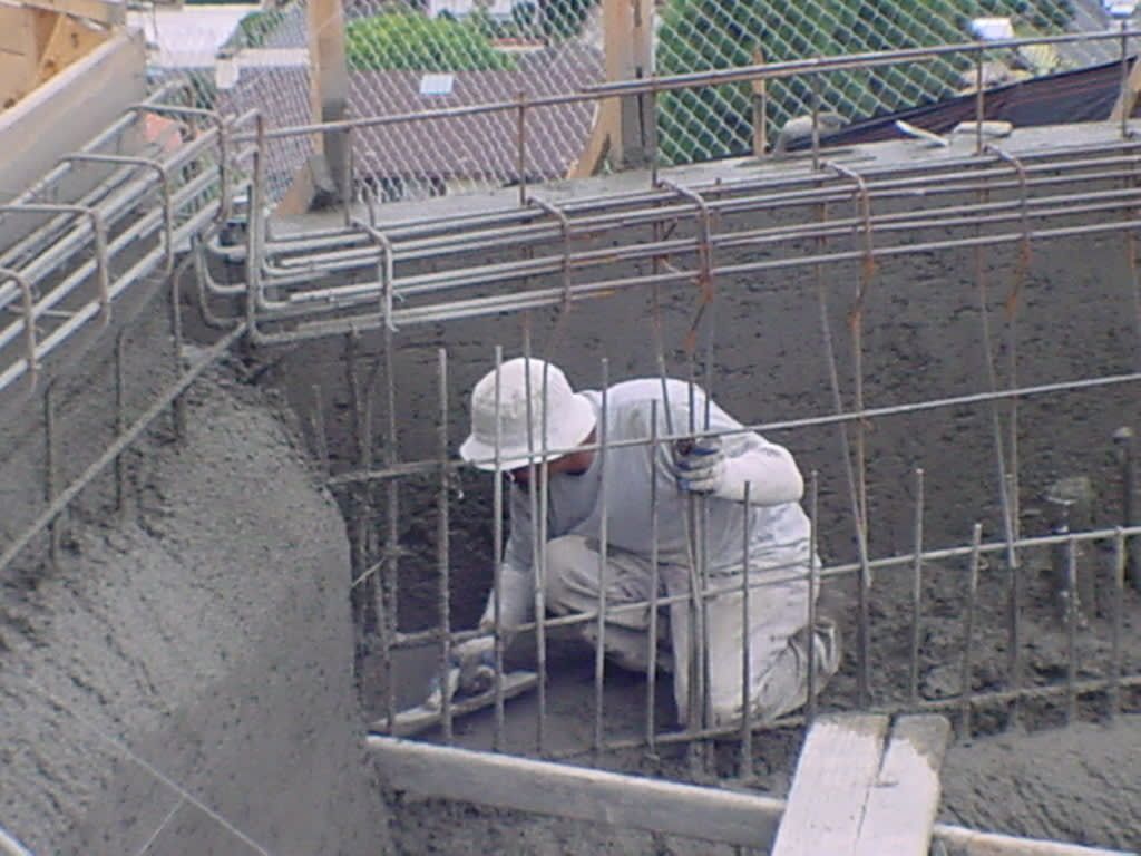 A man wearing a hard hat is working on a construction site