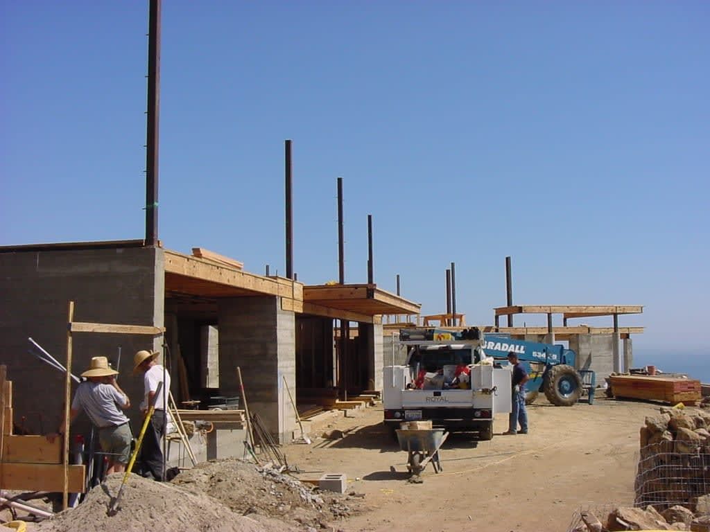 A blue Hyundai truck is parked in front of a building under construction.