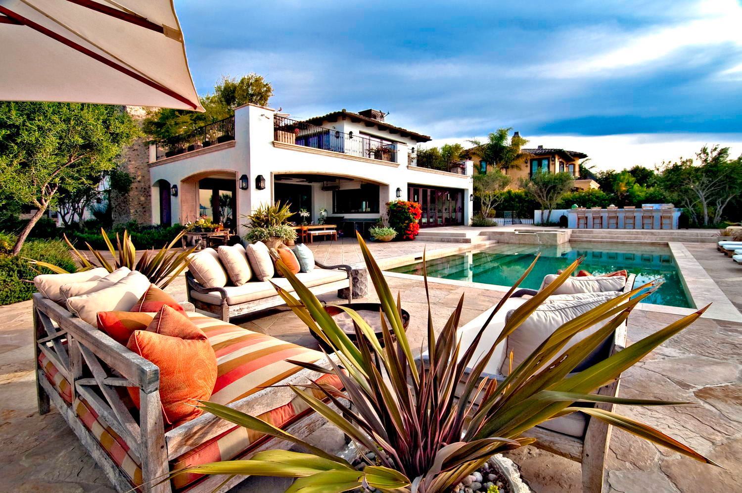 A large house with a swimming pool in front of it.