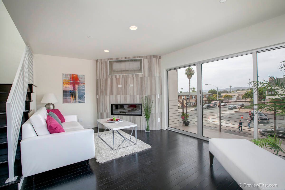 A living room with a white couch and a fireplace.