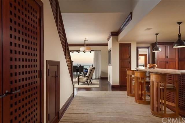 A hallway with a staircase leading up to a living room.